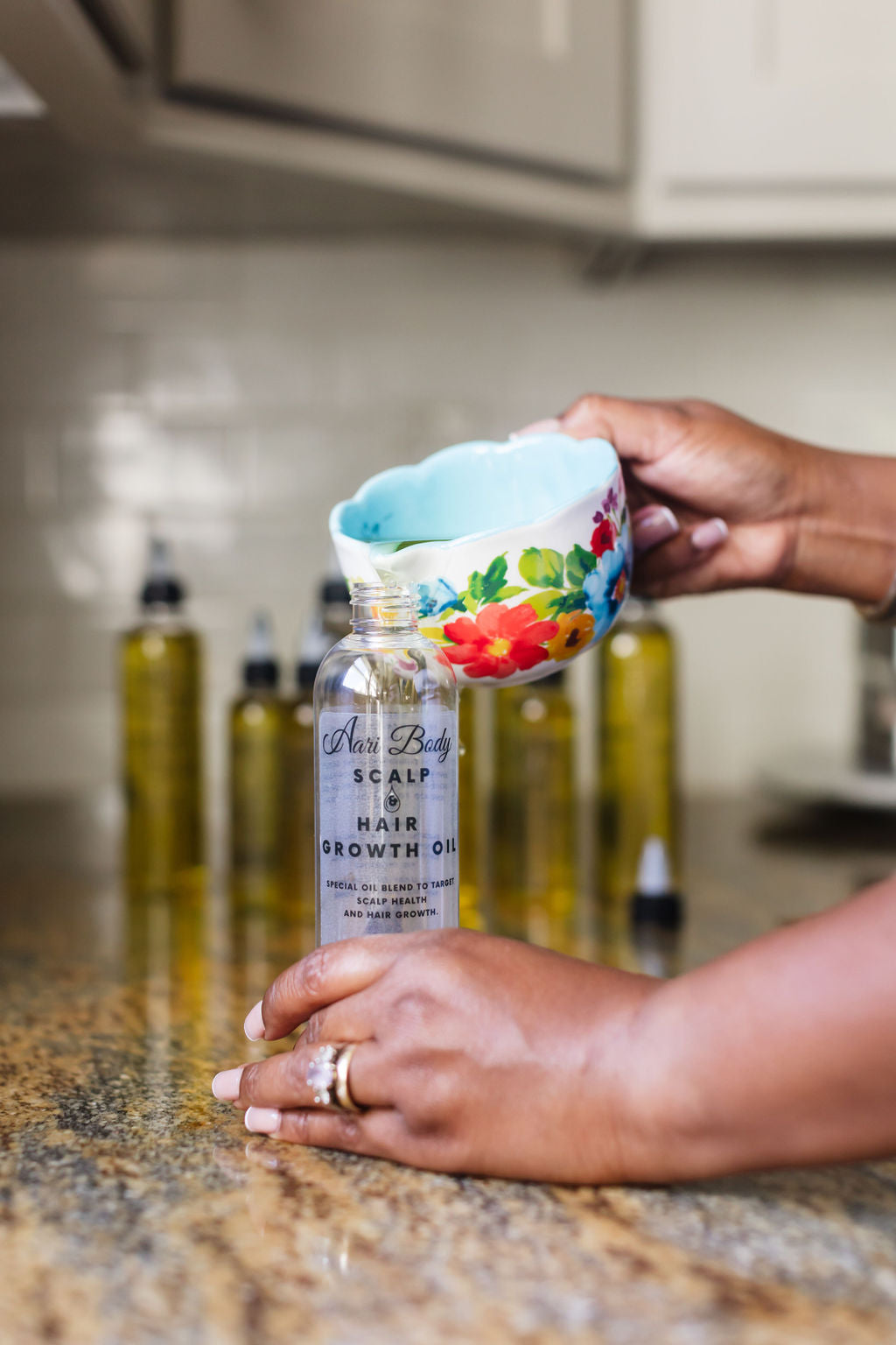 Hand pouring oil into a scalp oil bottle